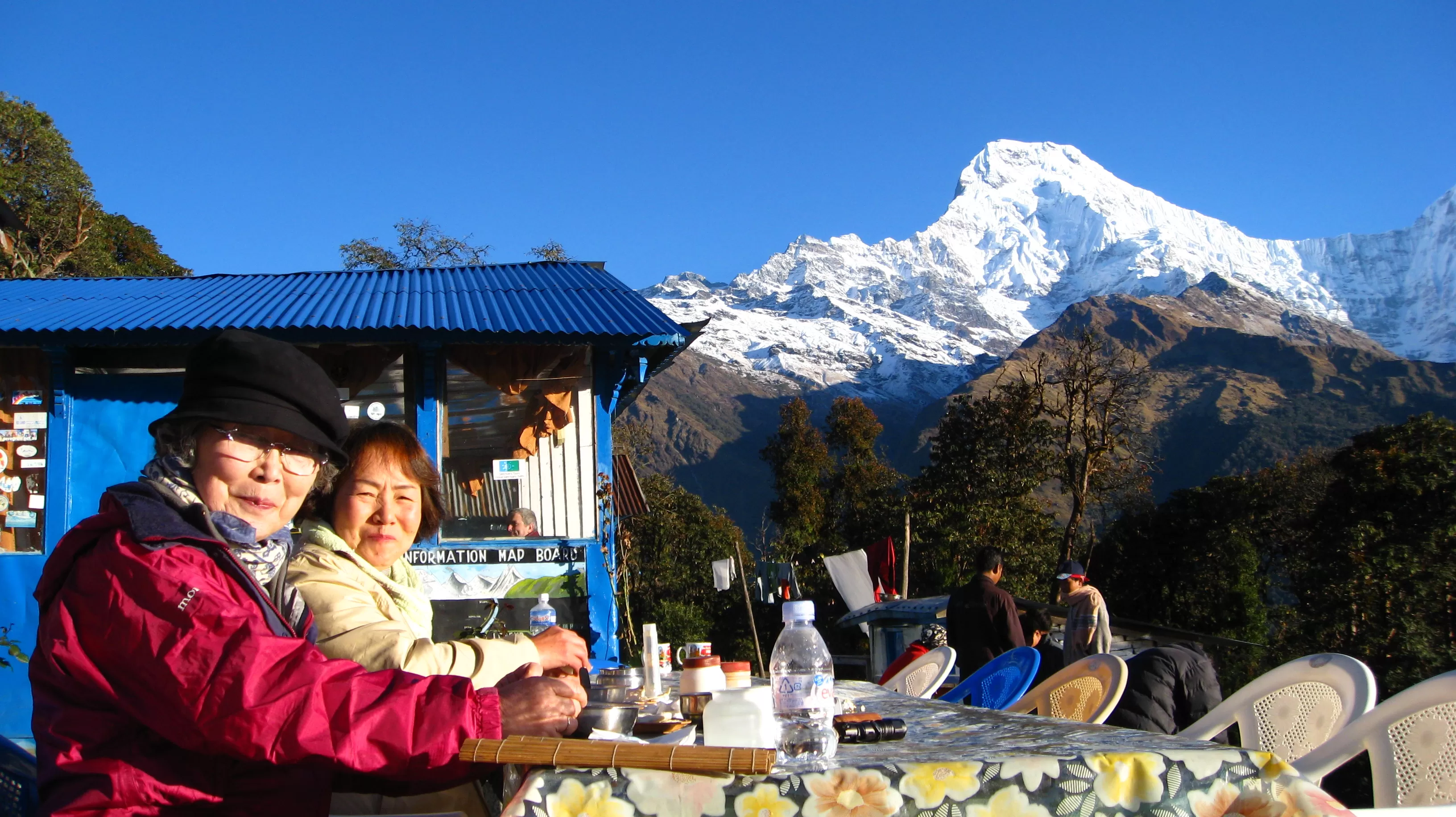 Group of senior women trekkers posing together in front of snow-capped Himalayan peaks in Nepal
